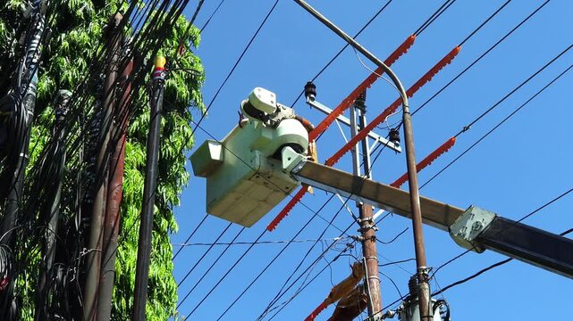 Professional Utility Linemen Installing Protective Insulation on Energized Medium Voltage Power Lines