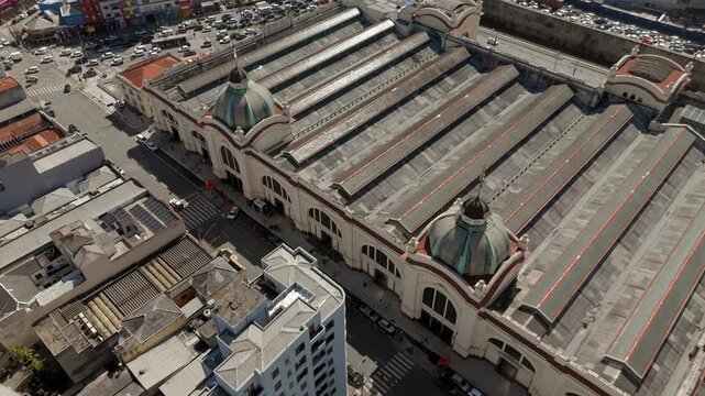 Aerial view of historic market domes and surrounding cityscape in S&atilde;o Paulo. Pan and tilt up camera movement