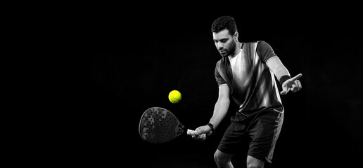 Fototapeta premium Padel tennis player. Man athlete with paddle tenis racket on black background. Sport concept. black and white
