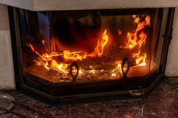 Fototapeta premium Fire in a fireplace in the living room with accessories