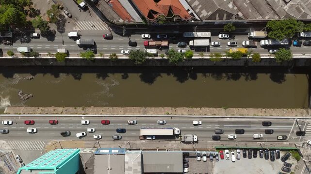 Aerial view of heavy traffic on marginal roads alongside Tamanduate&iacute; river in S&atilde;o Paulo, Brazil. Static camera shot.