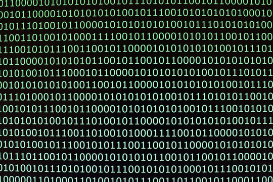 Green binary code fills black computer screen. Rows of zeros and ones create digital pattern. Technology background covers programming and data. Computer code forms abstract texture. Cyber concept.
