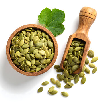 Top view of wooden bowl and scoop of fresh pumpkin seed with leaf on white background