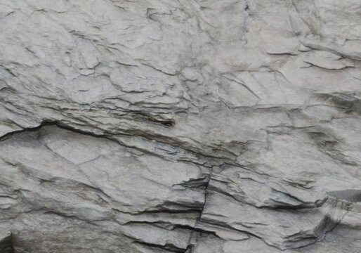 Rugged grey stone background with prominent dark fissure and rough grain.