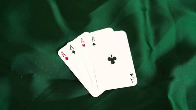 Four aces playing cards arranged in a fan on green velvet fabric background poker game gambling