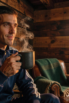 Man holds dark ceramic mug while steam rises into warm sunlight against wooden cabin wall interior. Side lighting accentuates facial features and swirling vapor trails.