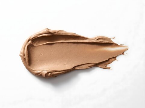 A smooth smear of beige liquid foundation cream showing thick glossy texture and rich pigment for professional makeup product advertising