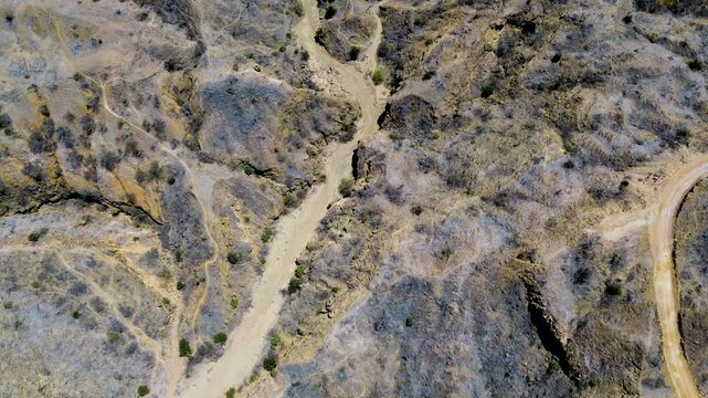 Top Down Drone View of Dry Ravines and Dirt Road in Coastal Ecuador, Arid Terrain, Erosion Patterns, Sparse Vegetation and Natural Texture