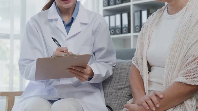Close-up of a doctor writing medical notes on a clipboard while consulting with a patient, representing healthcare service, diagnosis, medical records, and clinical support.