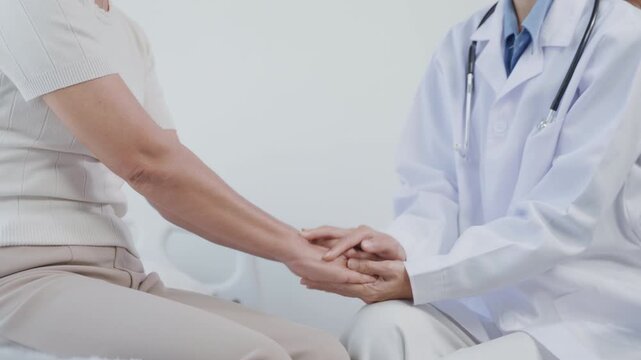 Close-up of a doctor gently holding a patient&rsquo;s hands to provide reassurance, compassion, and emotional support in a healthcare setting.