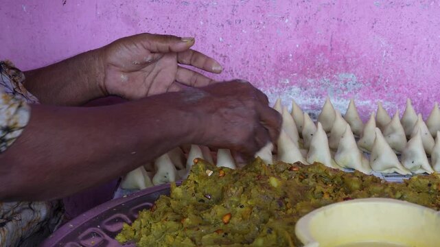 Hand filling samosa dough with spicy potato mixture