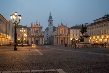 Obraz premium Turin, piedmont, italy. November 20, 2024. Early morning light illuminating famous baroque churches, historic buildings, equestrian statue, and cobblestone square in turin, italy