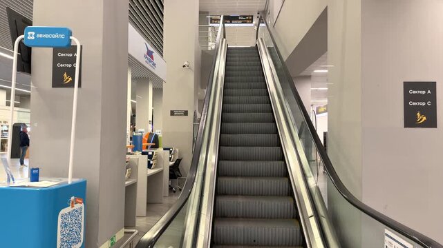 Twin escalators leading through a modern interior of a public facility. Efficient movement, architectural design, urban transport, accessibility, everyday travel.