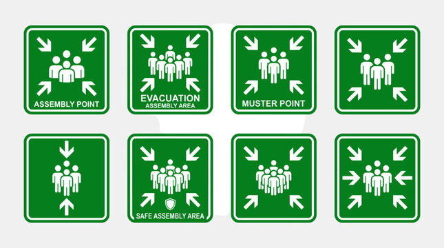 Collection of green safety signs indicating assembly points and evacuation routes.