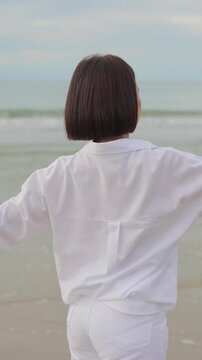 Woman stretching on a peaceful beach at sunrise, embracing relaxation, mindfulness, wellness, and the calming beauty of the ocean.
