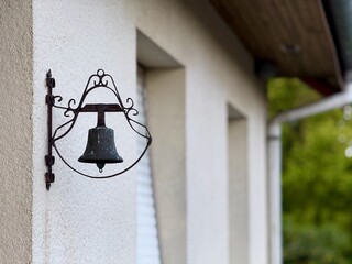 Obraz premium Old bronze wall-mounted doorbell with a decorative wrought iron