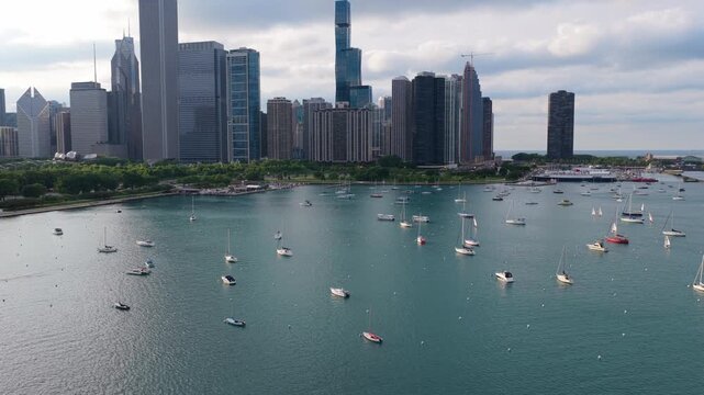 Sailing on Monroe Harbor with sailboats and yachts at anchor in front of Chicago's urban metropolis skyline in Illinois, prominent John Hancock Center