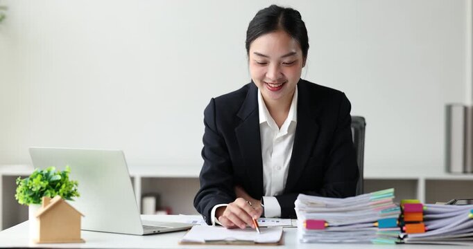 Businesswoman concentrating on a large stack of documents, managing heavy workload