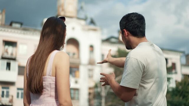 Man showing local historycal house and sights to his girlfriend outdoors