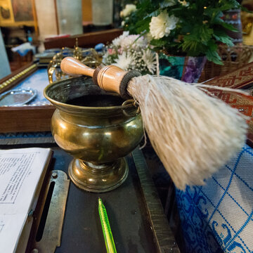 Holy water bowl with aspergillum in church interior