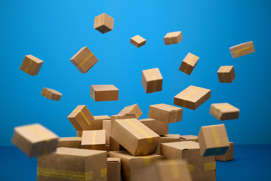 Cardboard boxes falling and piling up against a vibrant blue