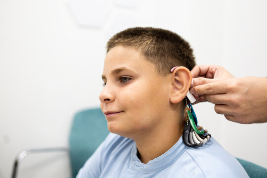 A child undergoes a hearing aid color fitting at a medical center. Concept of choosing a hearing aid color or colors.