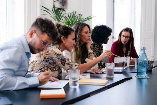 Board of directors reviewing financial reports during meeting 
