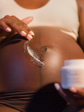 Pregnant woman using anti stretch mark cream 