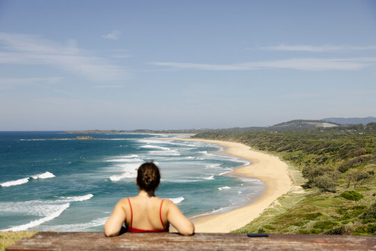 Woman watching beach from coastal lookout in Wollongong Australia