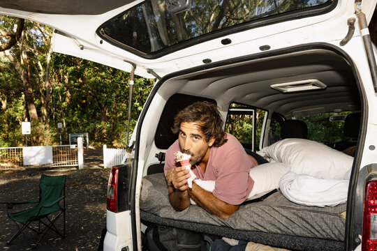 UGC man eating ice cream inside campervan with direct flash