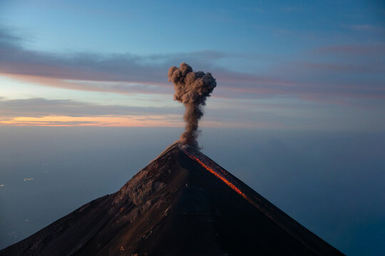 Active Volc&aacute;n de Fuego erupting lava and smoke column at dawn