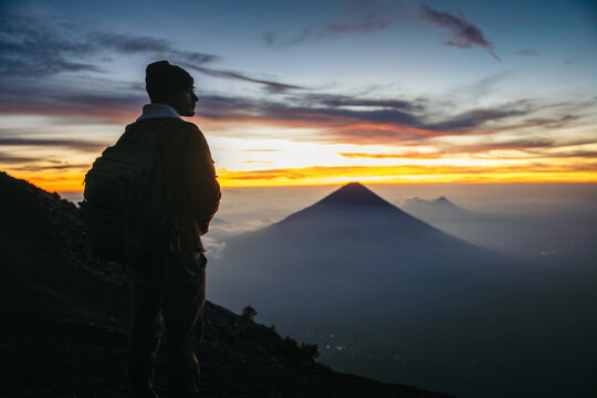Backpacker looking at Volc&aacute;n de Agua sunrise from Acatenango