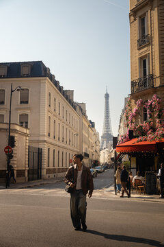 Man crossing a Paris street with the Eiffel Tower in the background