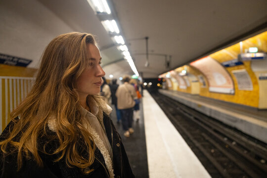 Young woman waiting on a Paris metro platform
