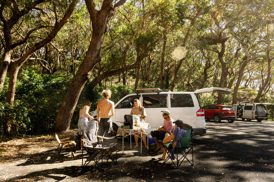 UGC friends cooking breakfast beside vans in national park