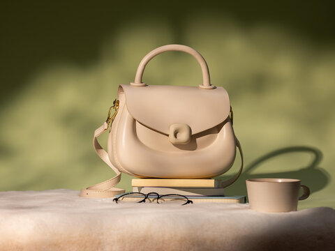 Elegant beige handbag with glasses and coffee cup on a stack of books