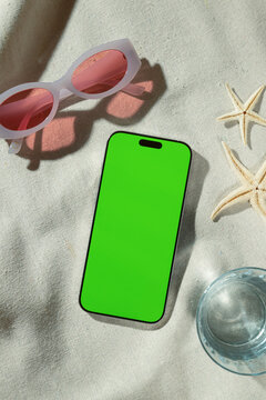 Summer vacation essentials: smartphone with green screen