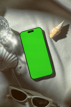 Glamorous makeup essentials and a smartphone with a green screen