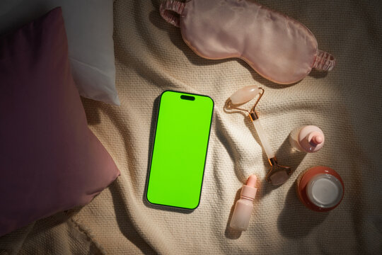 Cozy bedtime routine with skincare products and a smartphone