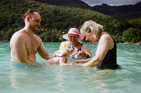 A family plays in the water in Seychelles