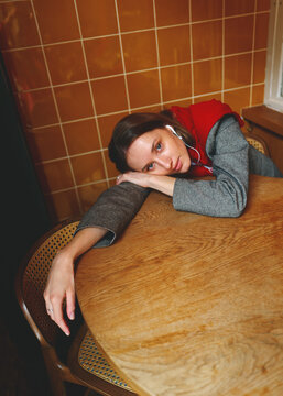 Young Person Resting Head on Table in Quiet Space
