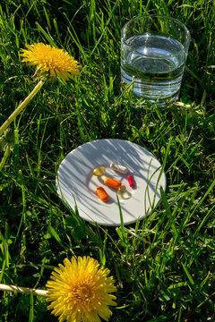 Natural Supplements and Vitamins with Water in Green Grass