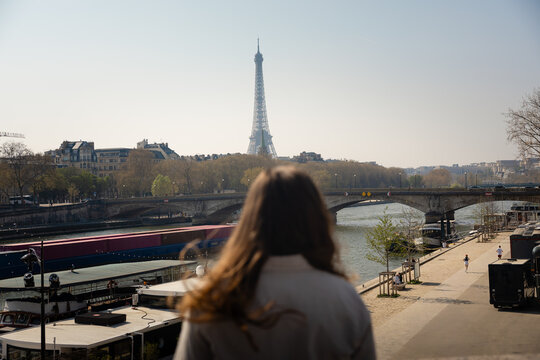 Woman looking at the Eiffel Tower and Seine River in Paris