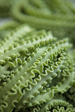 Freshly made pasta. Pasta made from durum wheat flour.The paste is green, colored with natural dyes. The rough surface of the fresh paste. An indicator of high quality. Healthy food.