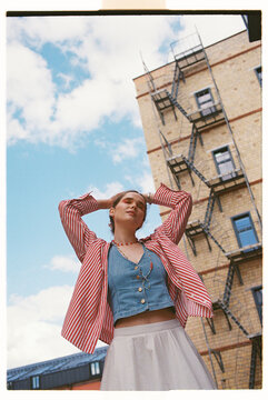 Young woman enjoys sunny weather in city downtown