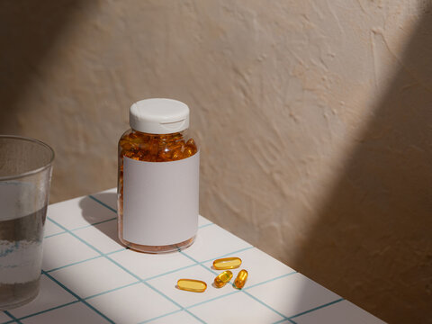 Bottle of amber-colored capsules and a glass of water