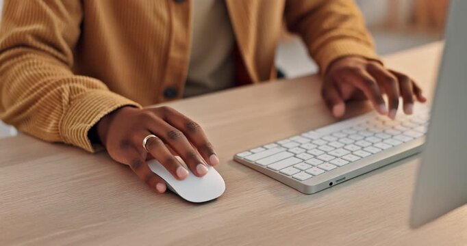 Close up of hands using computer mouse and keyboard on desk in office