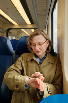 Woman on a train looking at her electronic watch, checking time