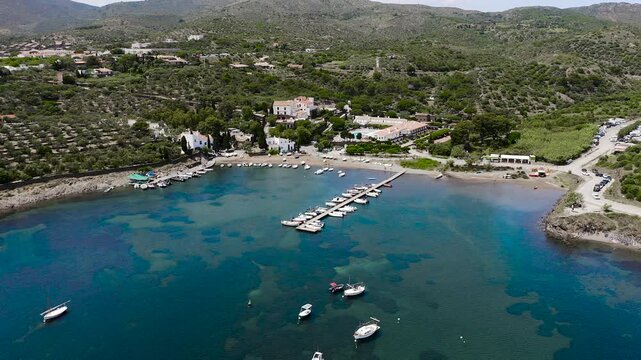 Aerial view of the peaceful Port Lligat Bay, home to Salvador Dal&iacute;'s House Museum, surrounded by crystal-clear Mediterranean waters, rocky shores and the unique landscapes of the Costa Brava. 
