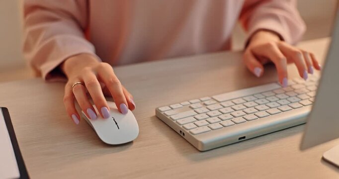 Woman hands using wireless mouse and keyboard on modern office desk